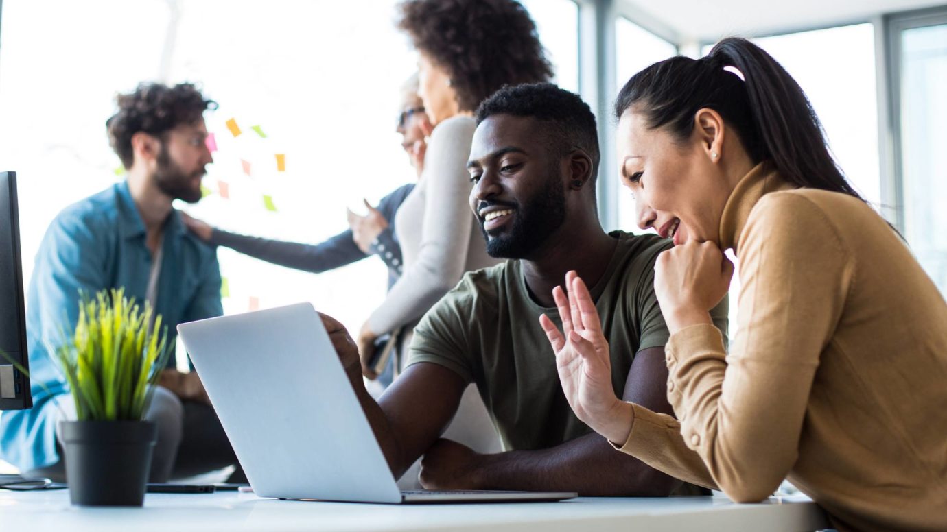 Employees looking at a laptop together