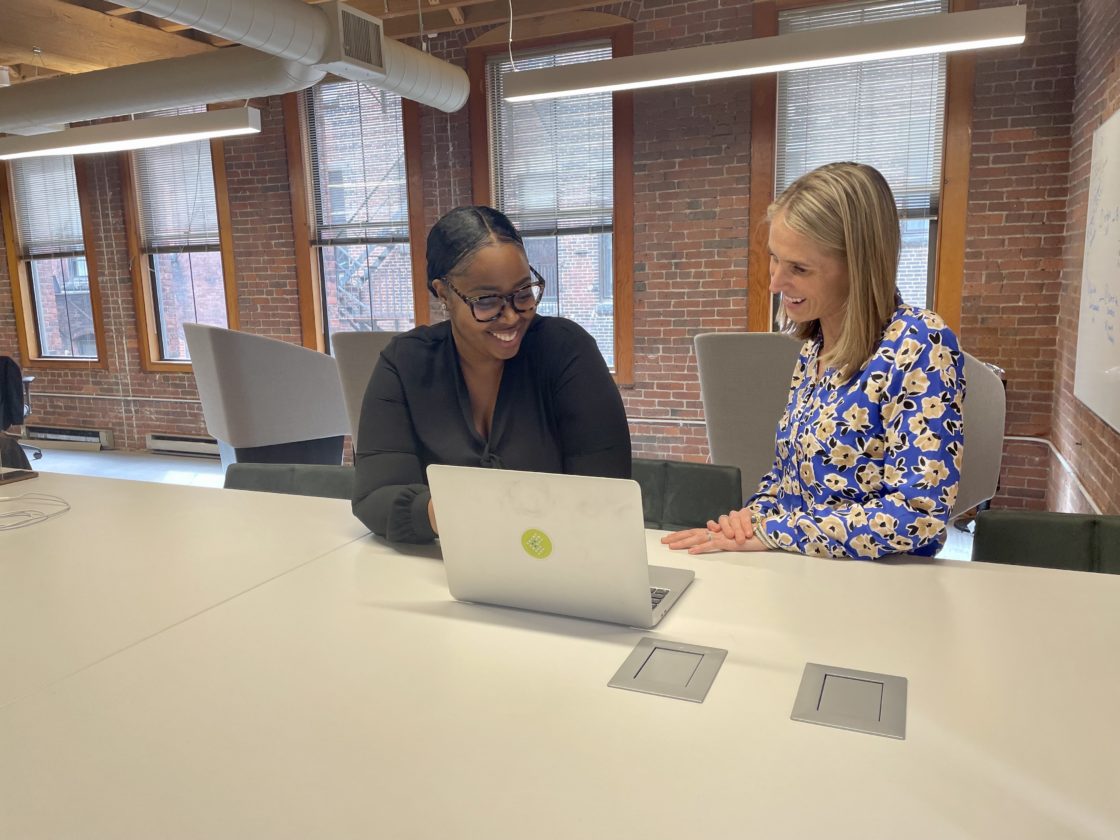 Two women working at a laptop in the Bowdoin office