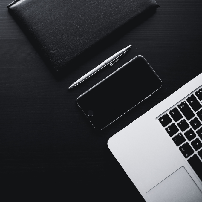 Photo of a desk that has a computer and phone